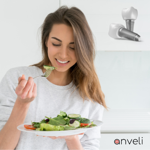 A woman eating salad after dental implant surgery