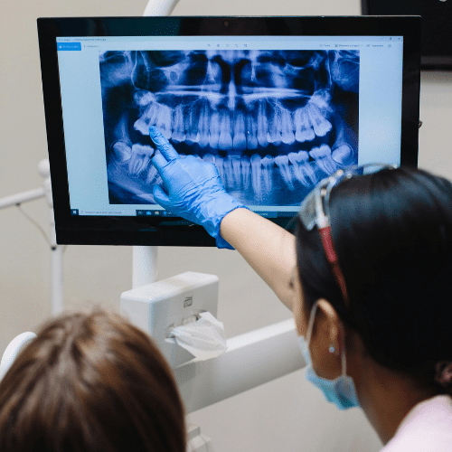 Dentist showing an X-ray of teeth to a patient.